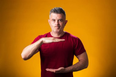 Büyük ve büyük boyut işareti gösteren el hareketleriyle insan portresi, sarı arkaplan üzerinde ölçü sembolü 