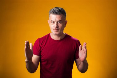 Büyük ve büyük boyut işareti gösteren el hareketleriyle insan portresi, sarı arkaplan üzerinde ölçü sembolü 