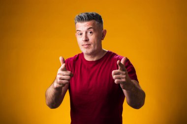 Gülümseyen adamın portresi sarı arka planda kamerayı işaret ediyor.. 