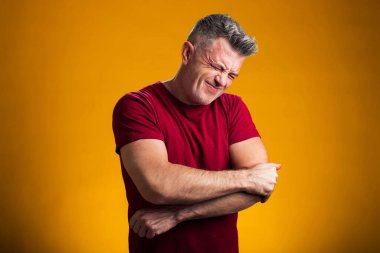 Arka planda dirsek ağrısından muzdarip bir adamın portresi. Halk, sağlık ve tıp konsepti