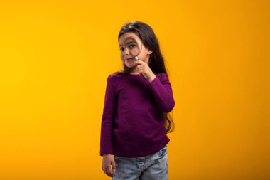 Elinde büyüteçle gülümseyen kız portresi. Eğitim ve merak kavramı