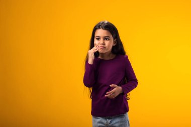 Diş ağrısından ya da dişlerdeki diş hastalığından dolayı elleriyle dudaklarına dokunan kızın portresi. Dişçi konsepti.