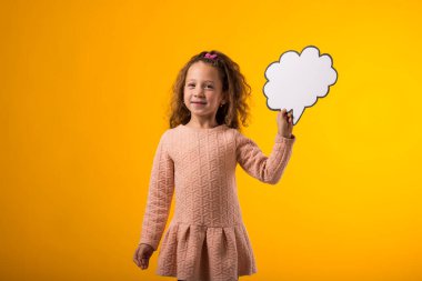 Sarı arka planda bulutlu kart tutan gülümseyen kız portresi. Rüya kavramı