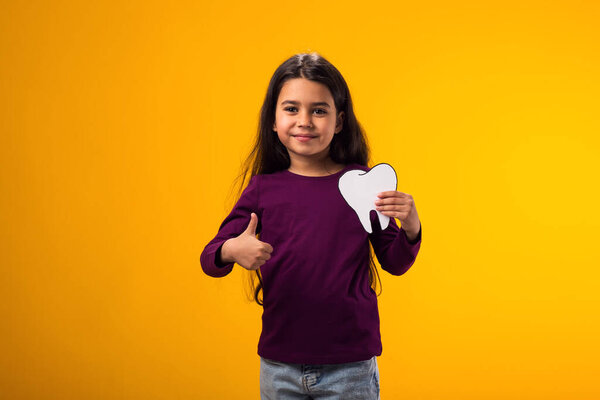 Portrait Child Girl Holding Papercraft Tooth Showing Thumb Gesture Yellow Royalty Free Stock Images