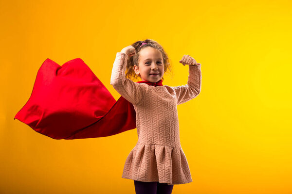 Portait Kid Girl Superhero Red Cloak Showing Strenght Gesture Yellow Stock Picture