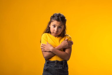 Kendini kucaklayan korkmuş bir kızın portresi. Olumsuz duygular konsepti