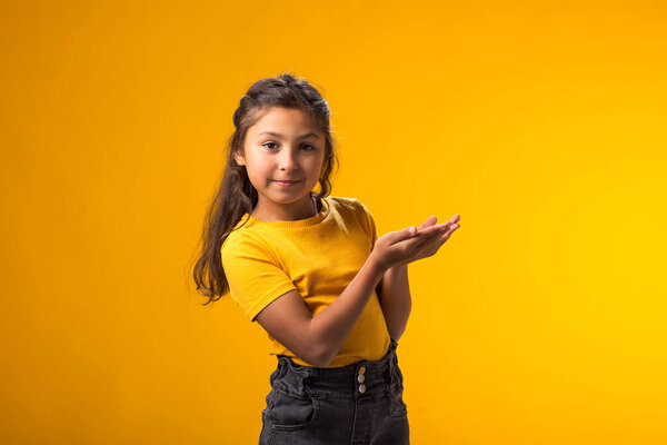 Smiling Child Girl Pointing Palms Empty Place Yellow Background Advertisement Royalty Free Stock Images