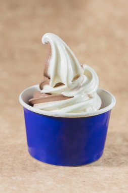 Kahverengi arka planda mavi bardakta vanilyalı dondurma, seçici odak