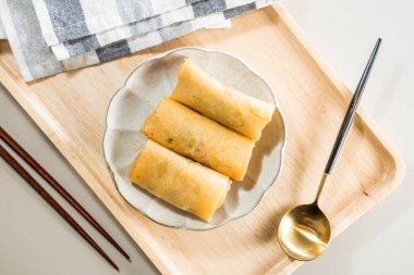 Yemek çubuğu ve kaşıkla kızarmış Çin böreği. Asya usulü.