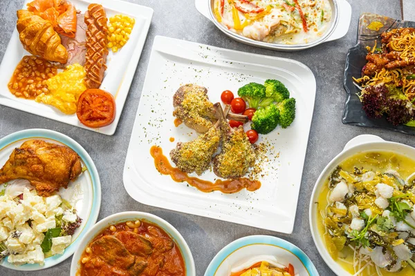 stock image Top view of a set of different dishes like lamb and fish and breakfast on a table in a restaurant