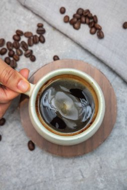 Kuş bakışı çekilen, bir kafede, bir fincan dumanı tüten sade kahve nazikçe bir masanın üstüne konur..