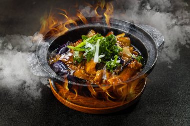 Cızırtılı bir buhar ve alev karışımı, Çin aromaswok kızartması, sokak stili klaypot yemekleri ve sıcak bir tencerede kaynayan balık aromalı patlıcan kokusu..