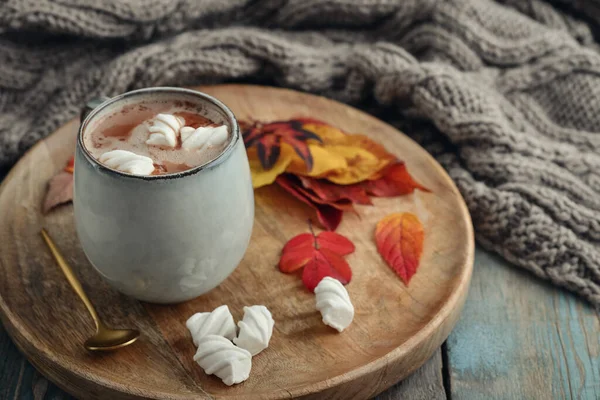 丸い木製のトレイにマシュマロと秋のカラフルな葉でおいしいホットココアのカップ — ストック写真