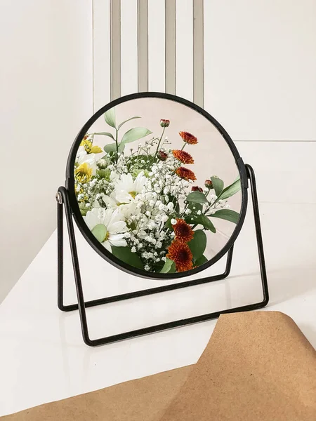 キッチンのインテリアにある白いテーブルの上の鏡に映る花瓶の中に異なる色の菊の花束 — ストック写真