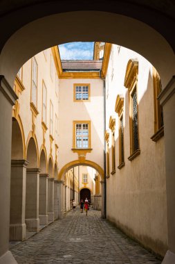 Avusturya 'nın Melk Abbey kentinde tarihi bir ara sokak, kemerli koridorlar ve doğal ışık altında yıkanmış bir kaldırım taşı yolu var..
