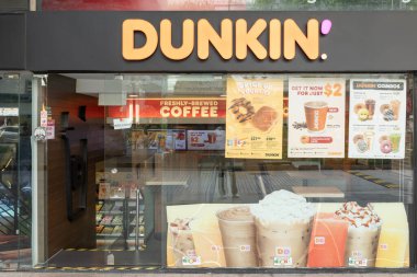 Singapur, Singapur - 01 Mayıs 2025: Dunkin Kafe önü Singapur Orchard Yolu 'nda renkli reklam tabelaları sergilenmektedir.