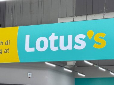  Lotus 'un adını gösteren ve renkli markalarla dolu bir markette yeni ürünler ve sunumlar sunan canlı bir tabela..