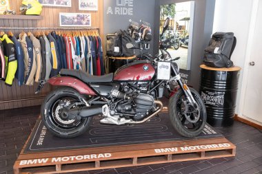  Bir motosiklet gururla bir BMW kuaföründe duruyor, binici kıyafeti ve aksesuarlarıyla çevrili, kalitesini ve işçiliğini gösteriyor..