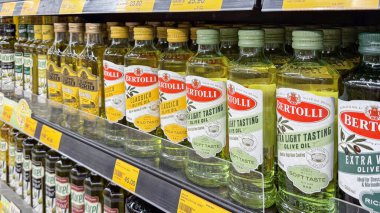  Farklı marka ve çeşitlerde Bertolli zeytinyağı şişeleri süpermarket raflarında sergilenerek, tüketiciler için canlı bir seçim sunuluyor..