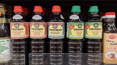  Perakende raflarda çeşitli Kikkoman soya sosları sergileniyor, farklı tatlar ve ambalaj tasarımı sergileniyor..