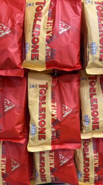  Parlak renkli Toblerone çikolata paketleri çekici bir perakende vitrininde satın alınmak üzere düzgünce düzenlenmiştir.
