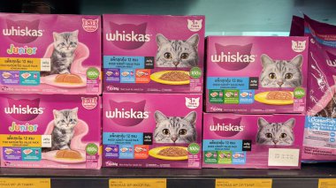  Raflarda değişik tatlar içeren küçük kedi maması paketleri ve neşeli kedi yavrularının çekici görüntüleri var..