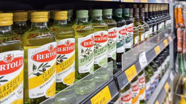 Penang, Malezya 17 Nisan 2025 Bertolli zeytinyağı şişeleri süpermarket raflarında sergileniyor, farklı etiketleri ve ambalajları sergileniyor.