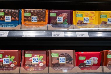 Penang, Malezya - 15 Nisan 2025: Fındık ve kakao aromalı Ritter Sport çikolatalarından oluşan bir koleksiyon, açık fiyatlı bir süpermarket rafında güzelce sergilenmektedir..