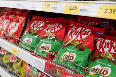 Penang, Malezya - 16 Nisan 2025 Nestl Kit Kat ve Milo çikolatalarından oluşan çeşitli paketler, 2.85 ve 2.39 fiyatlarında bir marketin rafında güzelce düzenlenmiştir..