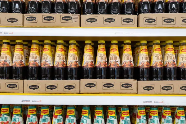 Penang, Malezya - 16 Nisan 2025: çeşitli etiketleri ve şişeleri düzgünce düzenlenmiş Maggi soslarıyla dolu raflar. Çeşitli tatlar belirgin bir şekilde gösteriliyor.