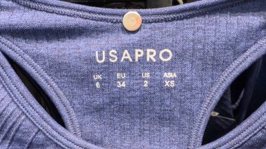 Penang, Malezya 18 Nisan 2025 Bir mağazada sergilenen atletik bluz için boyut bilgilerini detaylandıran bir giyim etiketinin yakın çekim görüntüsü.