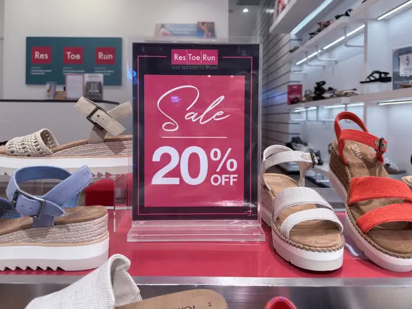 Penang, Malezya 23 Nisan 2025 Renkli sandaletler, modern perakende ortamında müşterileri cezbederek% 20 indirimli bir satışa teşvik ediyor..