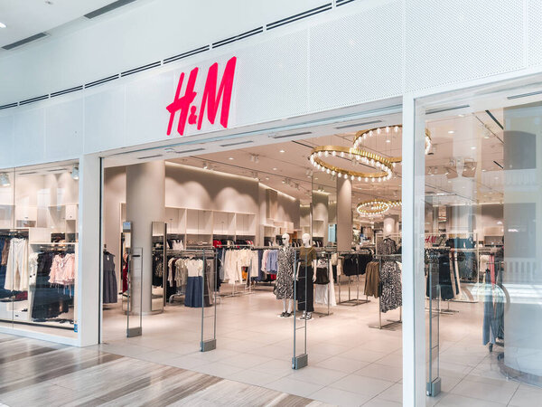 Пенанг, Малайзия - 7 июля 2025 года: интерьер магазина H andM украшен вешалками с одеждой, современным освещением и открытой планировкой в яркой торговой среде.
