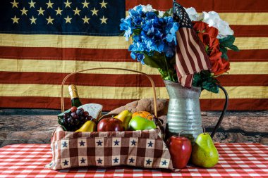 Piknik sepeti kareli masa örtüsü çiçek buketi ve Amerikan bayrağı arkaplanı