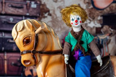 Antika palyaço bebeği eski tavan arası geçmişi olan eski bir hobi ata biniyor.