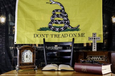 Silah ve İncil eski kütüphanedeki ahşap masanın üstünde. Radyosu ve sarısı kaliteli. Bayrak arkaplanıma basma.