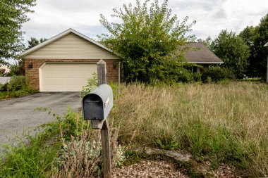 abandon brick ranch home with overgrown landscape and old mail box clipart