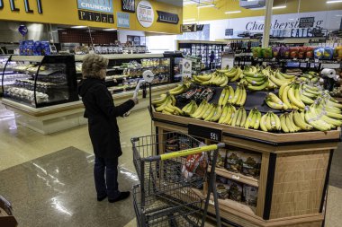 Chambersburg Pennsylvania ABD 1-9-2025 Kadınlar yerel süpermarketin üretim bölümünde muz alışverişi yapıyorlar