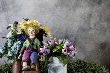 bahar çiçeği buketi ve antika bebek gri arka planı ve kopyası için odası olan kırmızı taburede oturuyorlar.