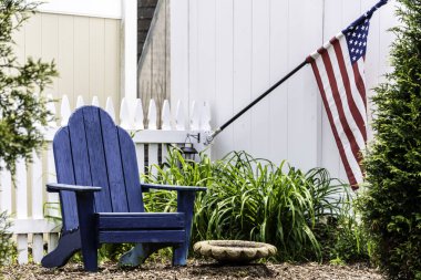 Arka bahçede Adirondack sandalyesi ve Amerikan bayrağı