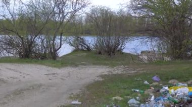 Nehir kıyısında plastik döküntüler. Doğanın kirliliği