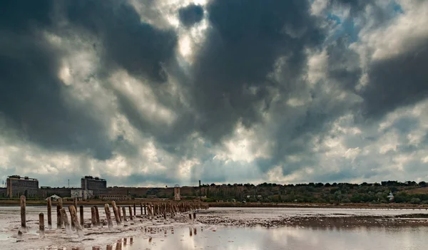 Stock image The bottom of the dried-up Kuyalnitsky estuary, covered with a layer of white self-precipitating table salt, clouds are reflected in the water