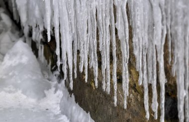 Ice icicles on frozen coastal rocks in the Black Sea