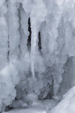 Ice icicles on frozen coastal rocks in the Black Sea