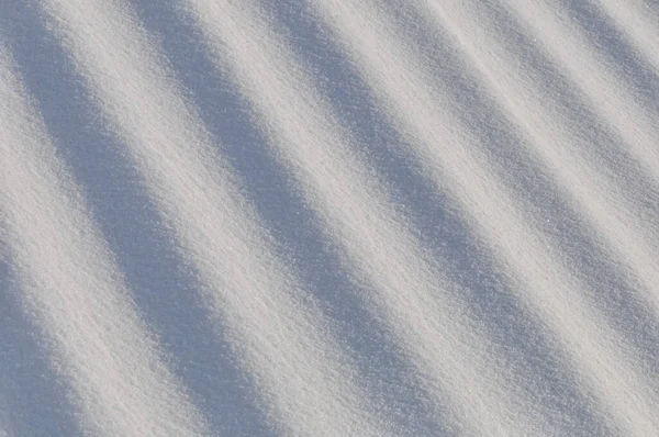 在寒冷的雪冬里 雪花成群结队地躺在地上 阳光直射而过 — 图库照片