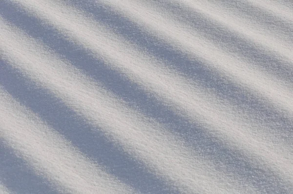 在寒冷的雪冬里 雪花成群结队地躺在地上 阳光直射而过 — 图库照片