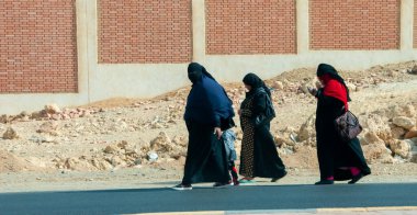 EGYPT, MARSA ALAM- 24 Şubat 2019: peçeli kadınların siluetleri çit boyunca yürüyorlar, Mısır