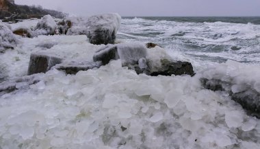 Donmuş Karadeniz, rıhtımdaki buzla kaplı ve donmuş kıyı kayaları, sert kış