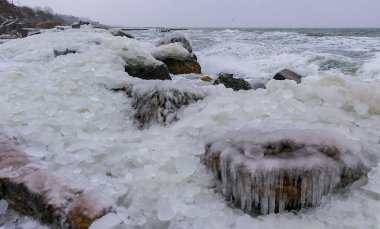 Donmuş Karadeniz, rıhtımdaki buzla kaplı ve donmuş kıyı kayaları, sert kış