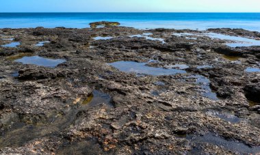 Kırım 'ın doğusunda, Karadeniz' de pek çok küçük su birikintisi olan düz kayalık bir sahil.